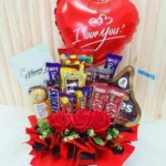 Best Of Love gift box with mixed chocolates, Hershey's Kisses, M&M's, fresh roses, and Love You balloon.