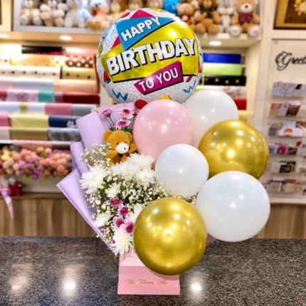 Birthday Box Flowers and Balloons with fresh flowers, pastel balloons, teddy keychain, and pink gift box in Karachi.