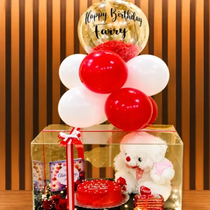 Birthday Charm Box with cake, red roses, teddy bear, KitKat chocolates, balloons, greeting card, and acrylic gift box.