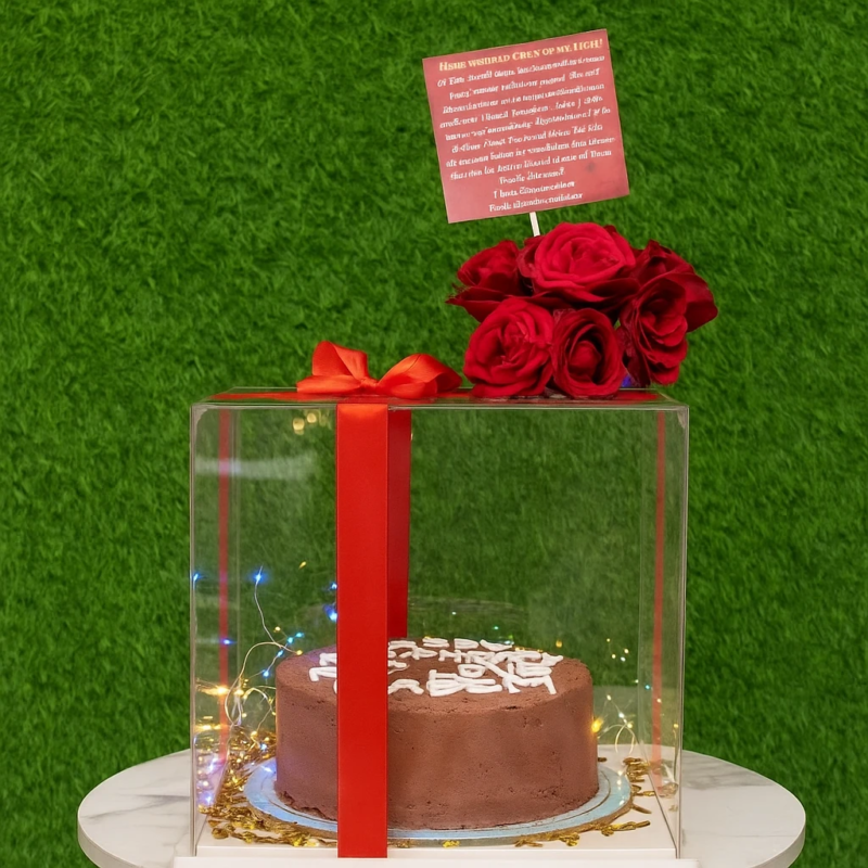 Cake With Acrylic Box featuring a 2.5 lbs chocolate cake, six fresh roses, ribbon decoration, and birthday tag.