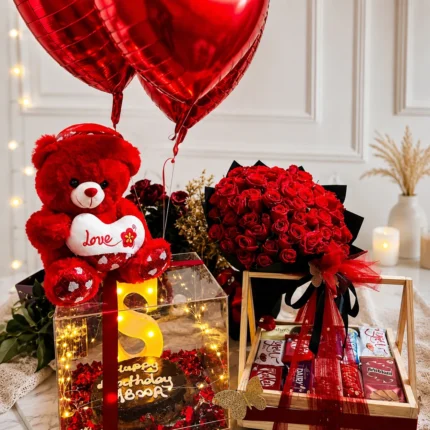 Romantic Love Celebration Hamper with red velvet cake, 4 dozen red roses, teddy bear, balloons, chocolates, and luxury wooden basket in Karachi.
